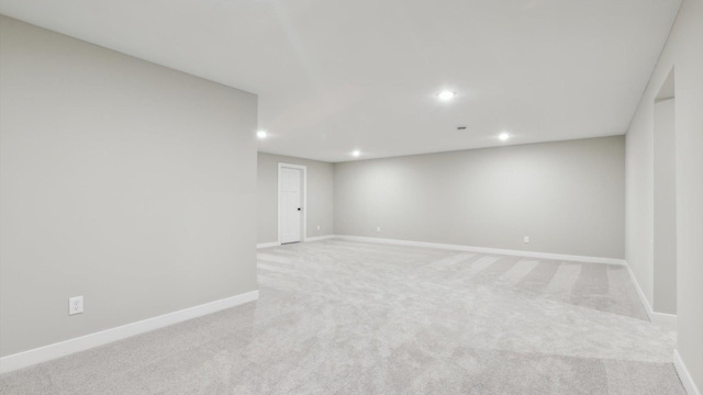 empty room with light carpet, recessed lighting, and baseboards