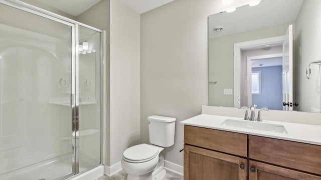 bathroom with a stall shower, toilet, vanity, and baseboards