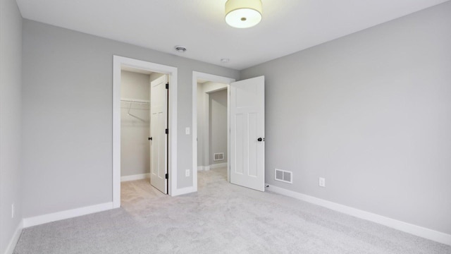 unfurnished bedroom featuring carpet flooring, a spacious closet, baseboards, and a closet