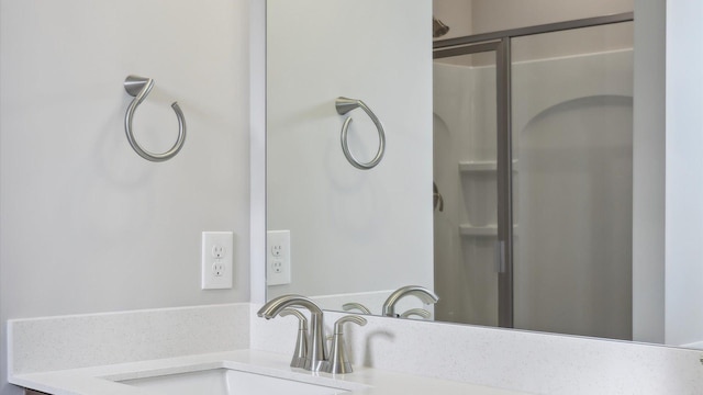full bathroom with a shower stall and vanity