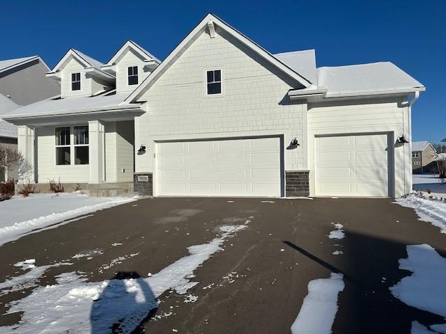 view of front facade with asphalt driveway and an attached garage
