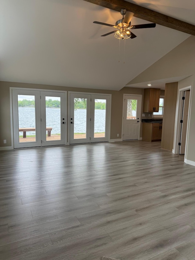 14646 Tradewinds Rd, Lake Eunice Twp, MN 56511 - unfurnished living room featuring baseboards, ceiling fan, light wood-style flooring, and a water view