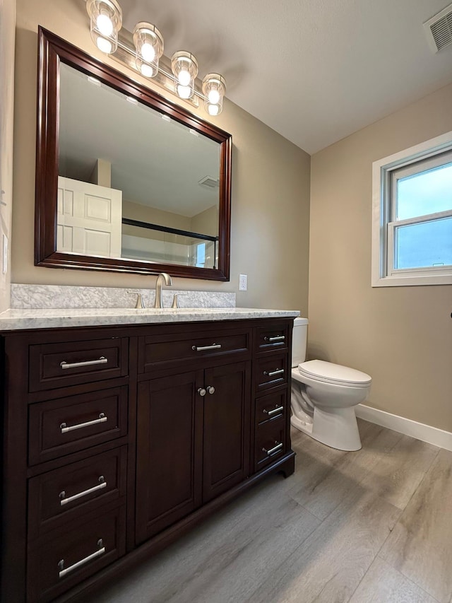 14646 Tradewinds Rd, Lake Eunice Twp, MN 56511 - bathroom with wood finished floors, baseboards, toilet, and vanity