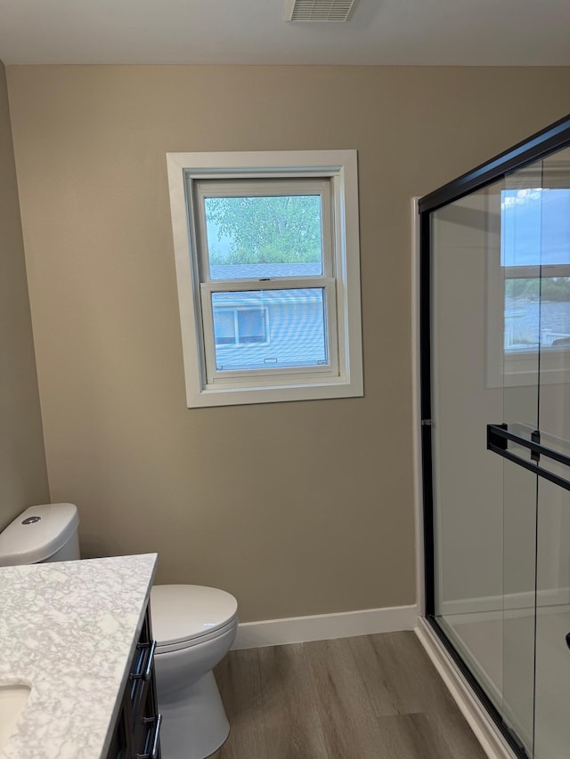 14646 Tradewinds Rd, Lake Eunice Twp, MN 56511 - bathroom with plenty of natural light, wood finished floors, vanity, and toilet