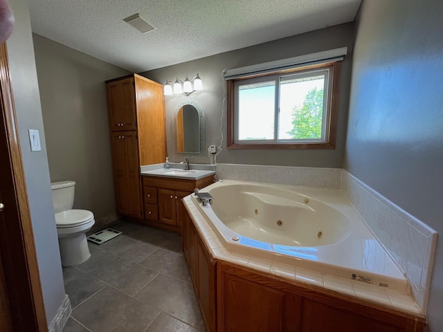 1803 214th Ave NE, East Bethel, MN 55011 - bathroom featuring a jetted tub, vanity, a textured ceiling, and tile patterned floors