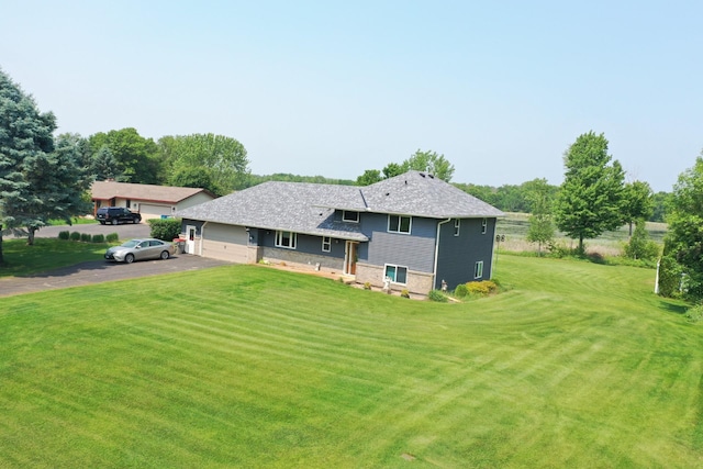 1803 214th Ave NE, East Bethel, MN 55011 - rear view of property featuring asphalt driveway, a yard, and a garage