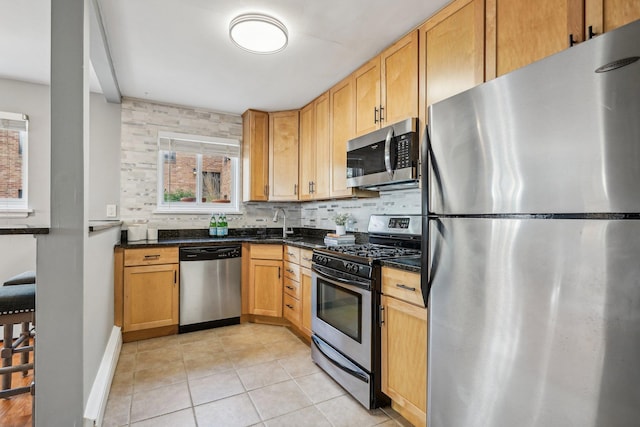 4515 Grand Ave S Unit 1, Minneapolis, MN 55419 - kitchen with appliances with stainless steel finishes, a sink, light tile patterned flooring, baseboards, and decorative backsplash