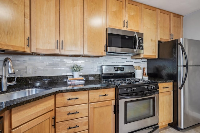 4515 Grand Ave S Unit 1, Minneapolis, MN 55419 - kitchen featuring appliances with stainless steel finishes, a sink, dark stone counters, decorative backsplash, and light tile patterned flooring