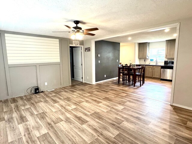 424 2nd St N, Greenbush, MN 56726 - living room featuring light wood-type flooring, ceiling fan, a textured ceiling, and baseboards