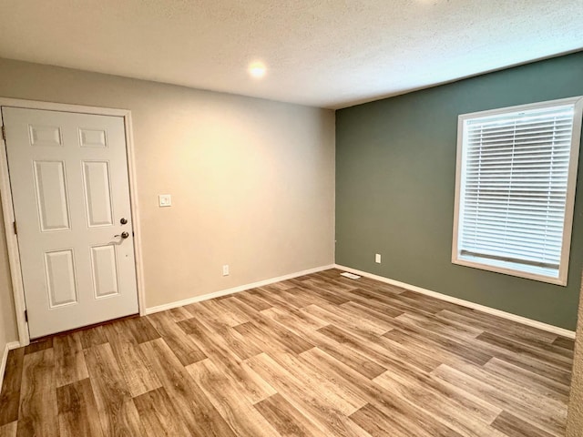 424 2nd St N, Greenbush, MN 56726 - unfurnished room featuring light wood-style floors, baseboards, and a textured ceiling