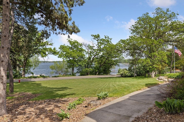 view of green lawn with a water view