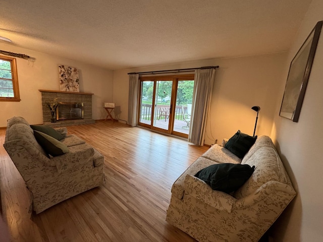 3401 Yukon Ave S, Saint Louis Park, MN 55426 - living area with wood finished floors, plenty of natural light, a stone fireplace, and a textured ceiling