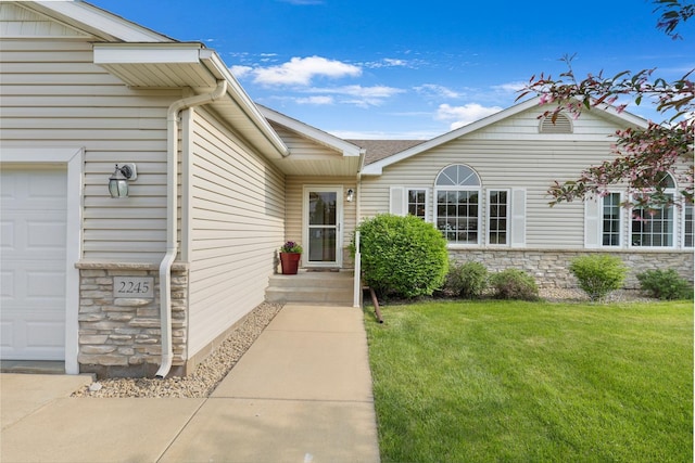 2245 198th St W, Faribault, MN 55021 - entrance to property featuring a garage, stone siding, and a lawn