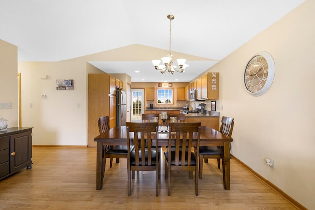 2245 198th St W, Faribault, MN 55021 - dining space with light wood-style floors, a chandelier, vaulted ceiling, and baseboards