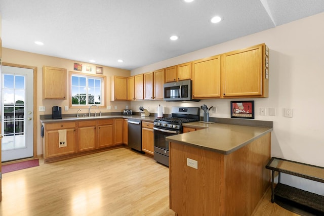 2245 198th St W, Faribault, MN 55021 - kitchen featuring appliances with stainless steel finishes, a sink, a peninsula, light wood-style floors, and recessed lighting