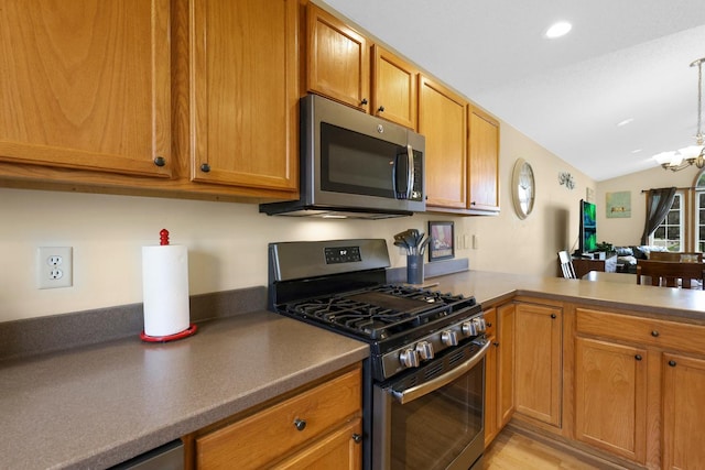 2245 198th St W, Faribault, MN 55021 - kitchen with appliances with stainless steel finishes, lofted ceiling, a chandelier, brown cabinetry, and light wood finished floors