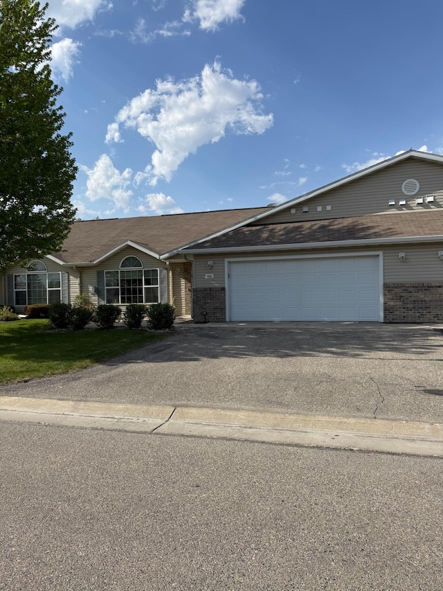 446 30th St N, Moorhead, MN 56560 - view of front of property featuring driveway, a garage, brick siding, and a front lawn
