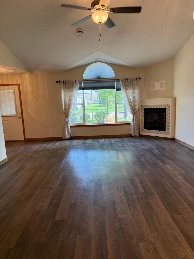 446 30th St N, Moorhead, MN 56560 - unfurnished living room with lofted ceiling, wood finished floors, baseboards, ceiling fan, and a tiled fireplace