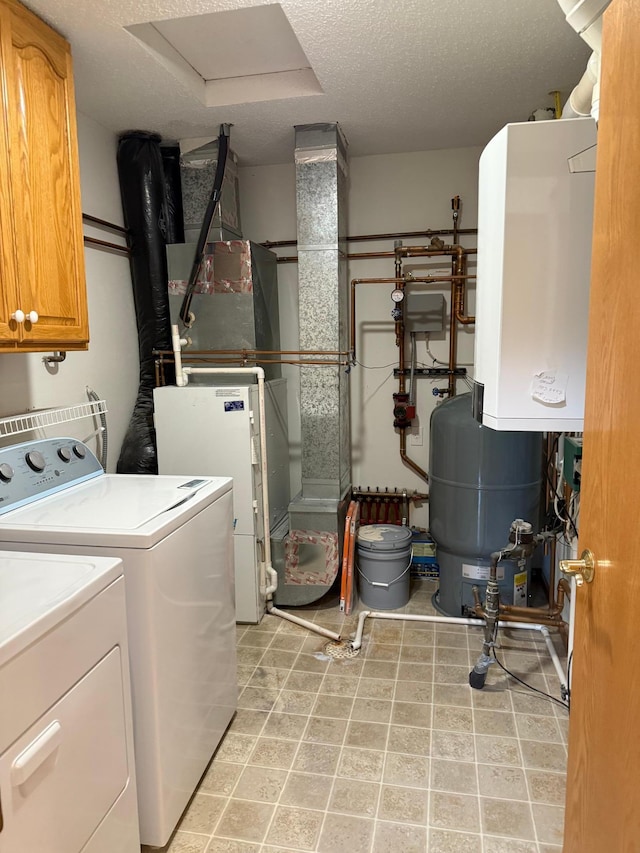 446 30th St N, Moorhead, MN 56560 - laundry room featuring cabinet space, washer and dryer, water heater, a textured ceiling, and heating unit