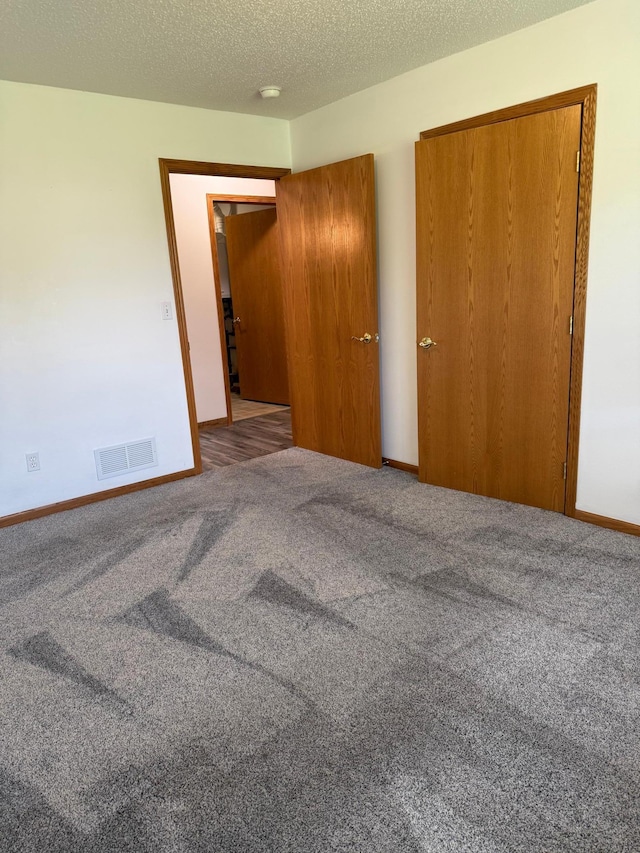 446 30th St N, Moorhead, MN 56560 - unfurnished bedroom featuring carpet, baseboards, a closet, and a textured ceiling