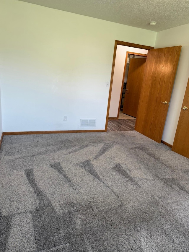 446 30th St N, Moorhead, MN 56560 - unfurnished bedroom with carpet flooring, baseboards, and a textured ceiling