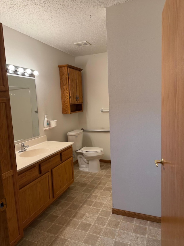 446 30th St N, Moorhead, MN 56560 - bathroom with toilet, vanity, a textured ceiling, and baseboards