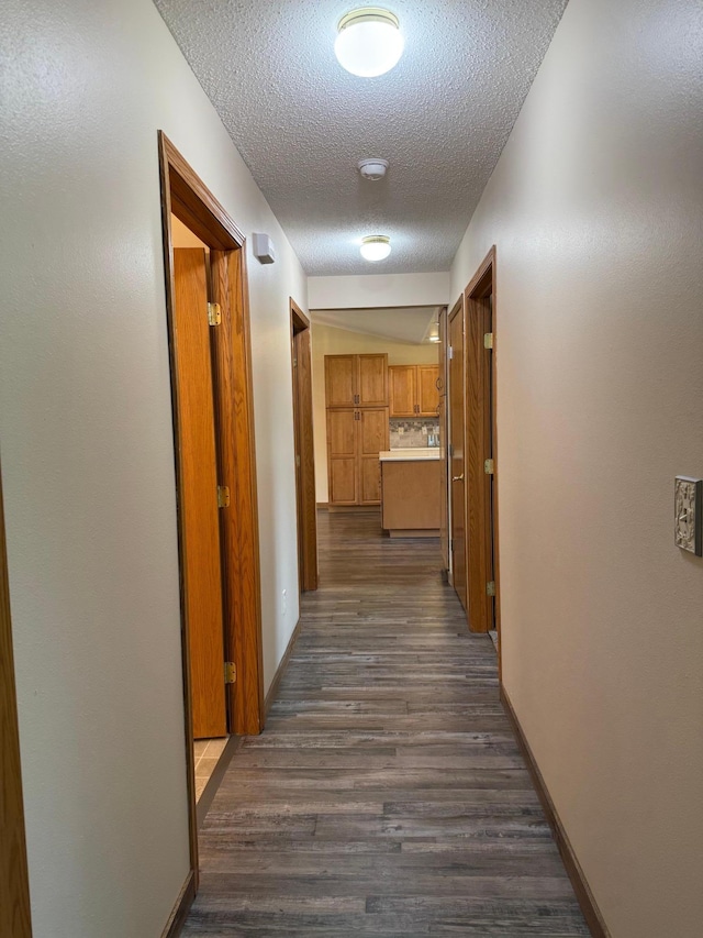 446 30th St N, Moorhead, MN 56560 - hall featuring a textured ceiling, dark wood-type flooring, and baseboards