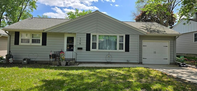 114 6th Ave, Albert Lea, MN 56007 - bungalow-style house with an attached garage, concrete driveway, a front lawn, and a shingled roof