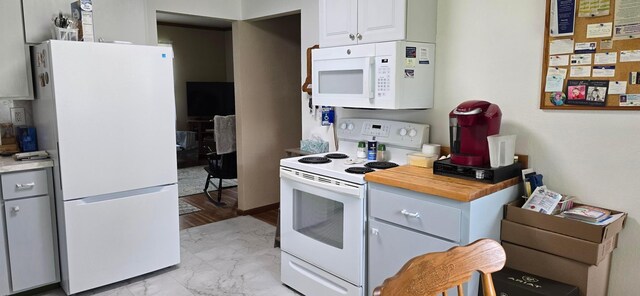 114 6th Ave, Albert Lea, MN 56007 - kitchen featuring white appliances, light marble finish floors, and white cabinetry