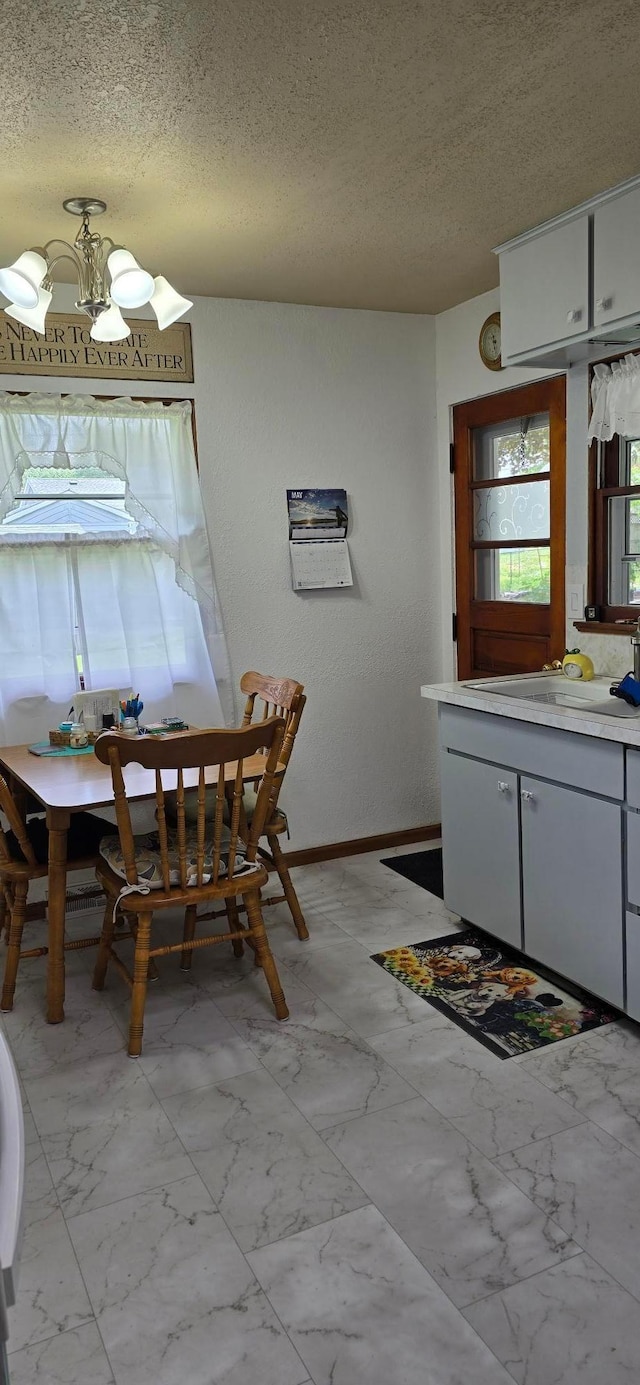 114 6th Ave, Albert Lea, MN 56007 - dining space featuring a textured ceiling, light marble finish flooring, and a chandelier