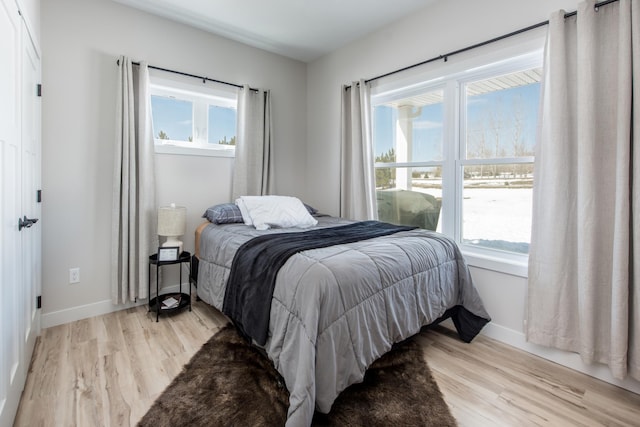 bedroom featuring light wood-style flooring and baseboards