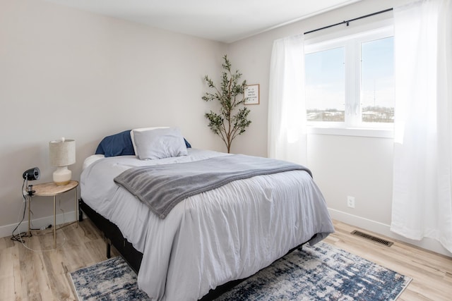 bedroom with light wood finished floors and baseboards