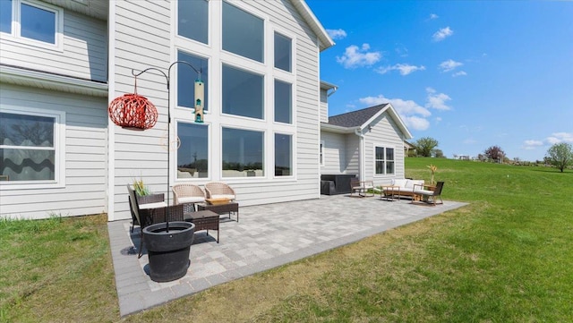 back of house featuring a patio area, a lawn, and outdoor lounge area