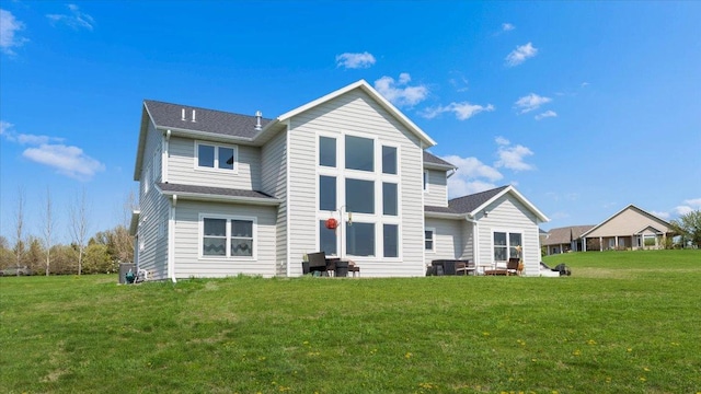 rear view of house featuring a yard