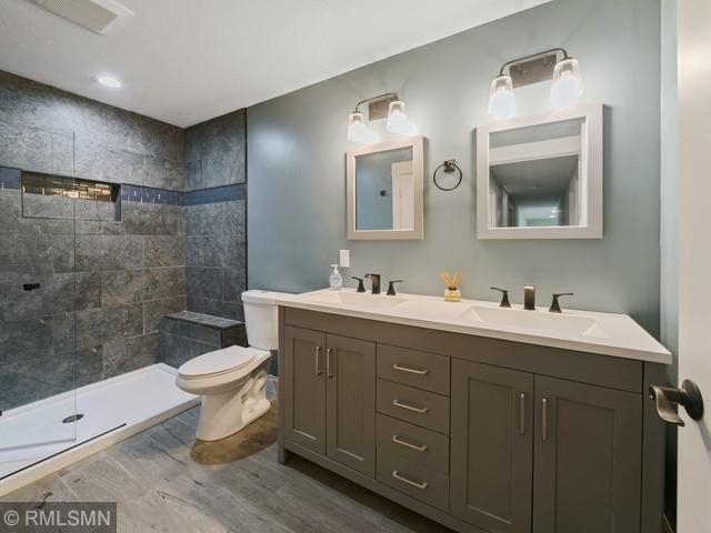 1706 57th Ave, Hammond, WI 54015 - full bathroom with double vanity, wood finished floors, and tiled shower