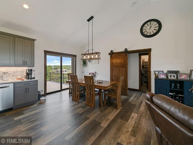 1706 57th Ave, Hammond, WI 54015 - dining room featuring a barn door, dark wood finished floors, lofted ceiling, and a chandelier