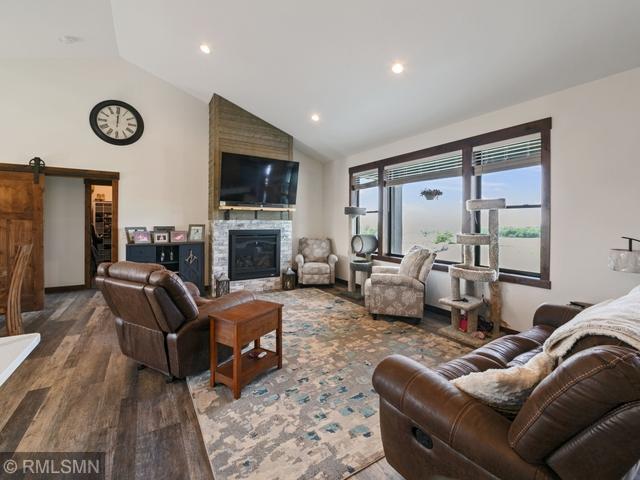 1706 57th Ave, Hammond, WI 54015 - living area featuring wood finished floors, a barn door, a fireplace, recessed lighting, and high vaulted ceiling
