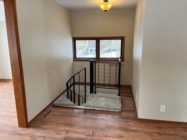 stairs featuring wood finished floors and baseboards