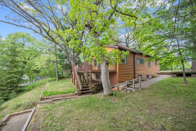 22718 Martin Lake Dr NE, Linwood Twp, MN 55092 - view of property exterior featuring a deck, log veneer siding, stairs, and a lawn