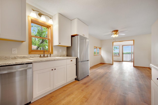 22718 Martin Lake Dr NE, Linwood Twp, MN 55092 - kitchen with appliances with stainless steel finishes, light wood-type flooring, white cabinetry, and a ceiling fan