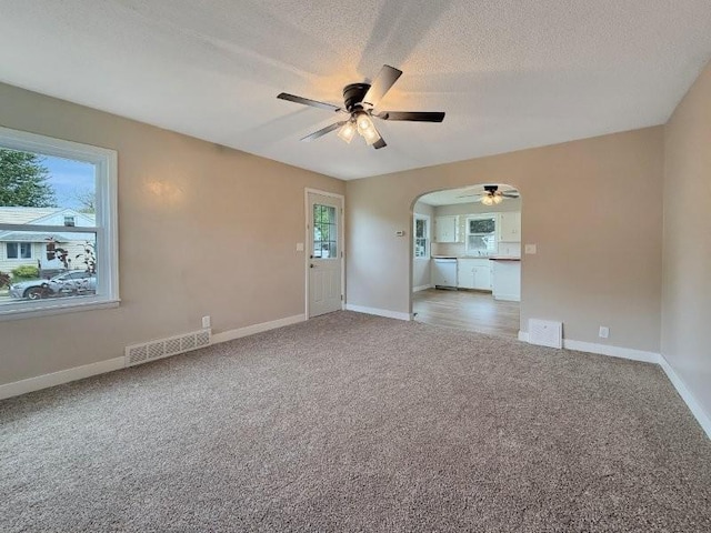 306 Blinkman St, Fairmont, MN 56031 - carpeted empty room with ceiling fan, arched walkways, a textured ceiling, and baseboards