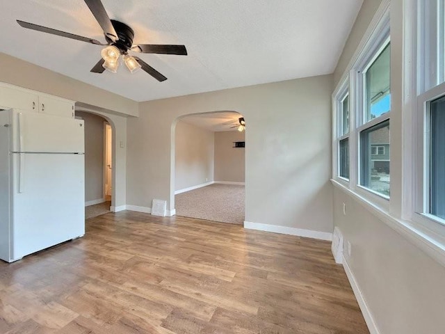 306 Blinkman St, Fairmont, MN 56031 - spare room featuring arched walkways, a ceiling fan, baseboards, and light wood finished floors
