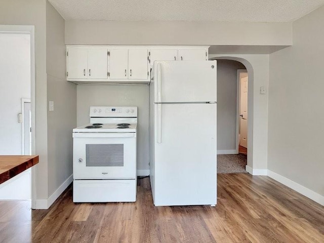 306 Blinkman St, Fairmont, MN 56031 - kitchen featuring white appliances, wood finished floors, arched walkways, white cabinets, and baseboards