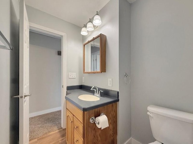 306 Blinkman St, Fairmont, MN 56031 - bathroom with wood finished floors, toilet, vanity, and baseboards