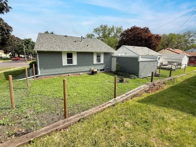306 Blinkman St, Fairmont, MN 56031 - rear view of property with a shed, a shingled roof, and an outbuilding