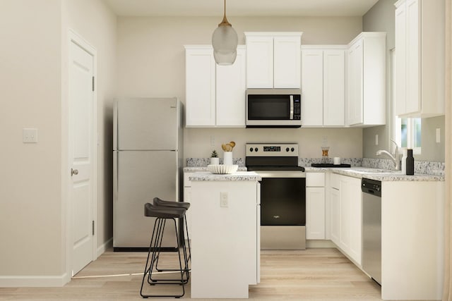 402 Redwood St N, Cambridge, MN 55008 - kitchen with appliances with stainless steel finishes, light wood-style flooring, a center island, white cabinets, and a sink