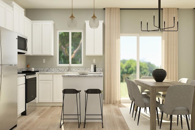 402 Redwood St N, Cambridge, MN 55008 - kitchen with stainless steel appliances, light wood-style floors, a chandelier, white cabinets, and pendant lighting