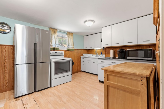 1391 Main St, Saint Joseph Twp, WI 54082 - kitchen with freestanding refrigerator, white range with electric cooktop, wooden counters, wood walls, and white cabinets