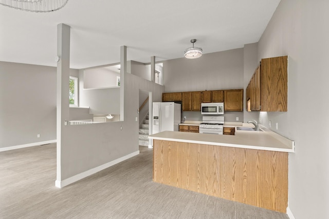 6007 Covington Ter, Minnetonka, MN 55345 - kitchen with white appliances, a sink, light wood-type flooring, light countertops, and a towering ceiling