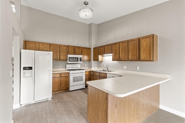 6007 Covington Ter, Minnetonka, MN 55345 - kitchen featuring white appliances, a sink, brown cabinetry, light countertops, and a high ceiling